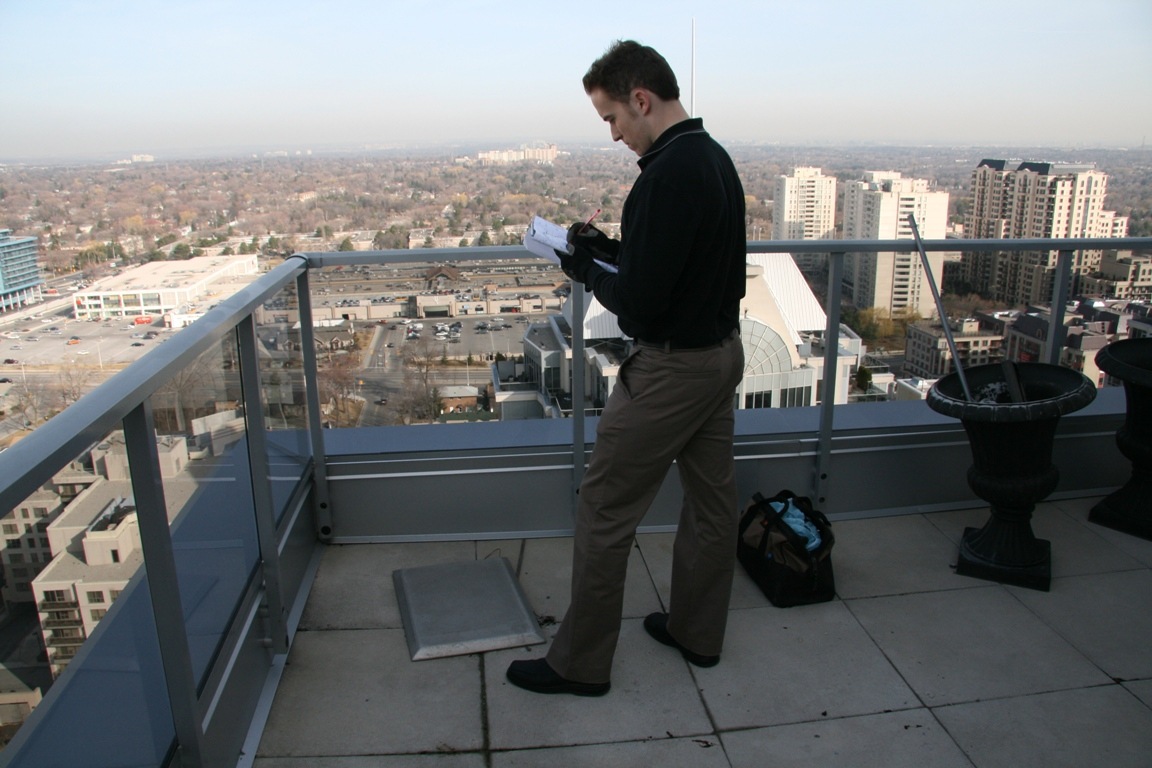 man inspecting fall protection on roof