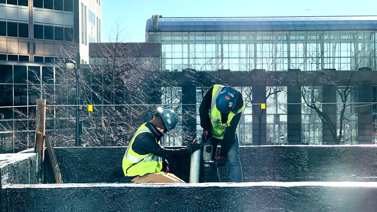 Two Pro-Bel employees installing a permanent roof anchor