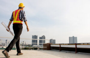 A general contractor approaching the parapet to access the fall protection system