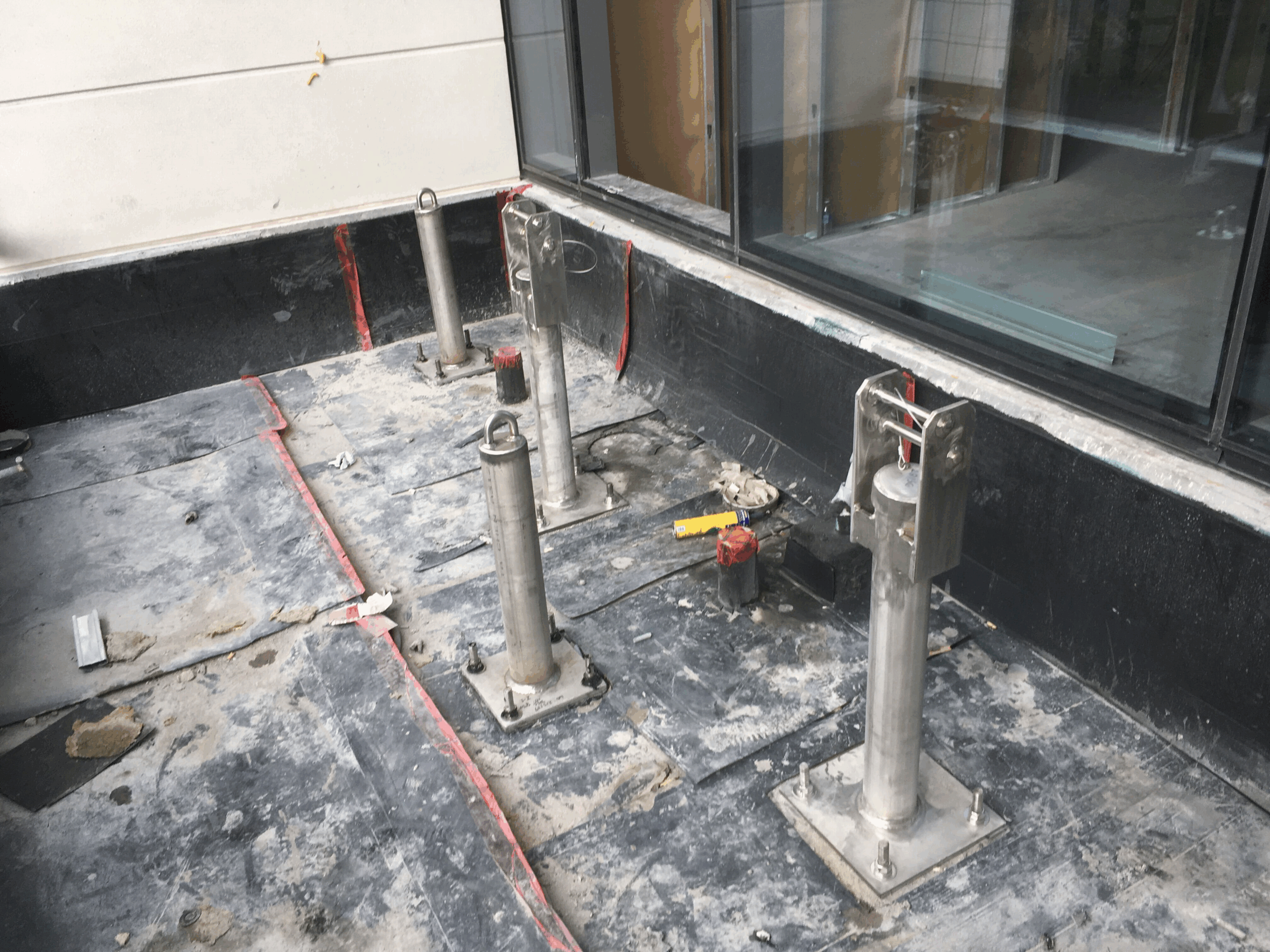 Two newly installed rigging sleeves and tieback anchors surrounded by construction materials